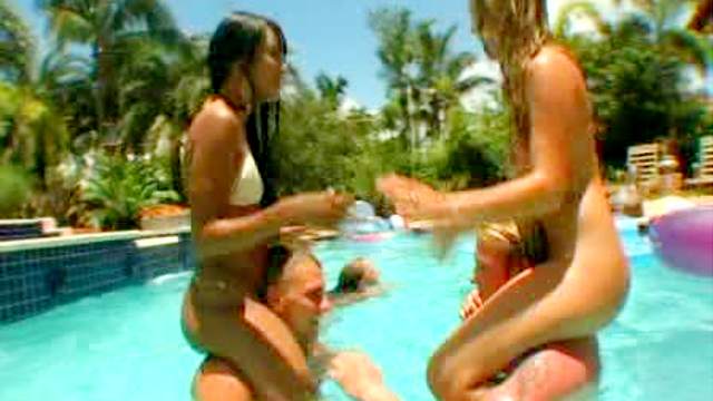 Ladies in bikinis play poolside