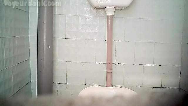 Redhead is pissing in the voyeur toilet