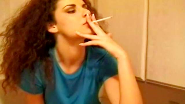 Clothed babe has a cigarette in the kitchen