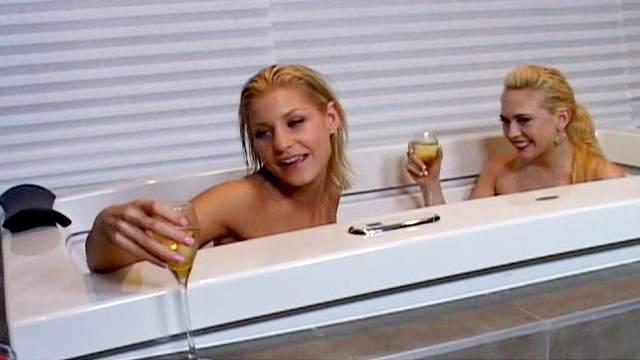 Blonde pornstars are drinking champagne in the bathtub