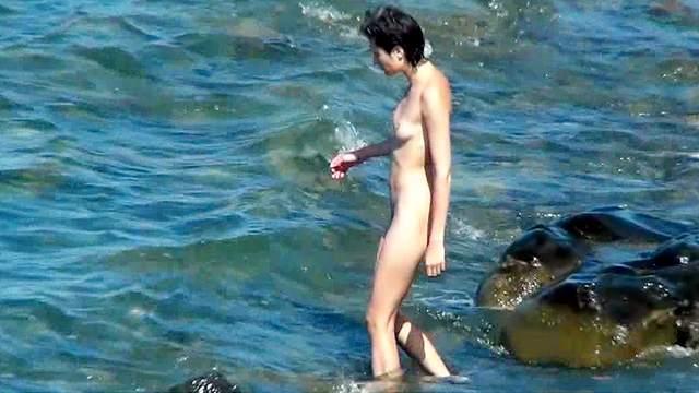 Tall brunette poses naked in the sea