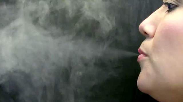 Latina blowing smoke sensually