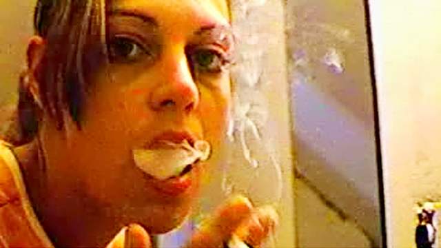 Sexy girl smokes in the mirror