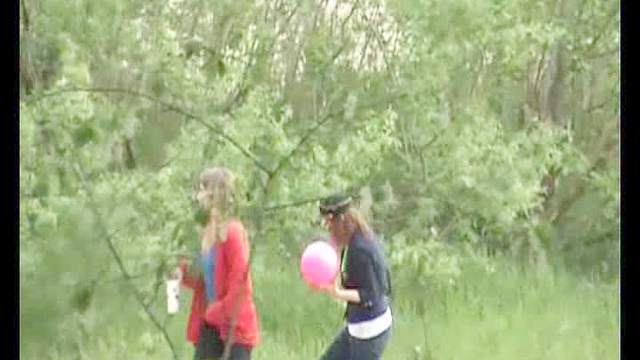 Two girls go pee in a field