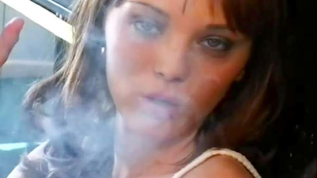 Sexy brunette in lipstick smokes cigarette