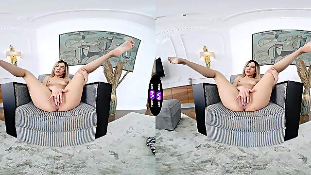 A blonde girl rubs her shaved pussy on the sofa in virtual reality