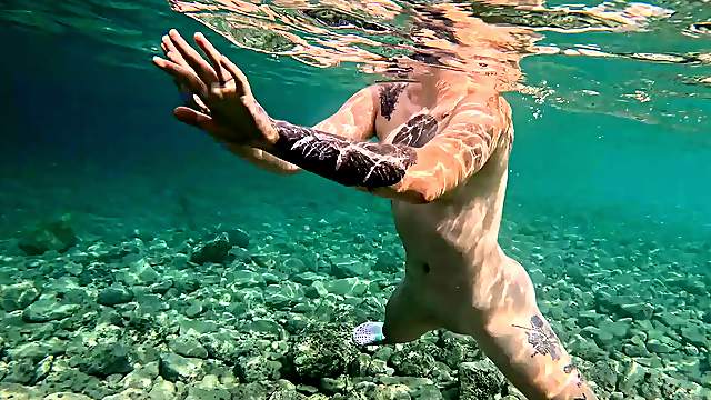 Tattooed brunette in glasses pleasures herself submerged