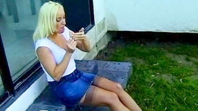 Blonde smokes outdoors in stockings