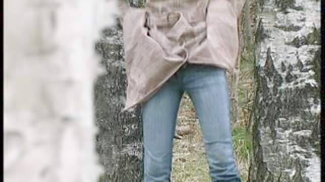 Girl in jeans pisses in the woods