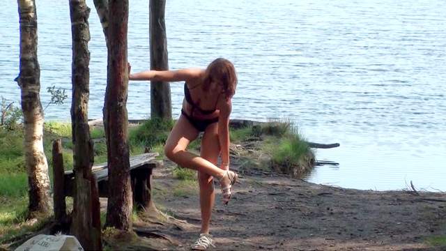 Teen poses by the the lake in a swimsuit