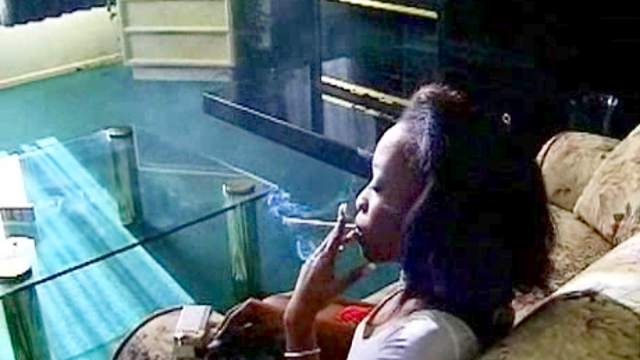 Black girl smokes cigarette solo