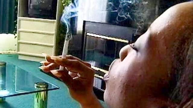 Black girl smokes cigarette solo