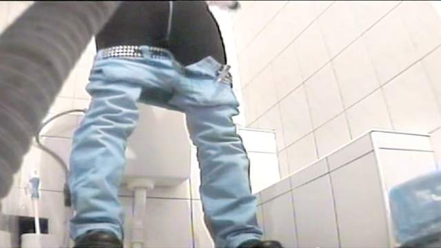 Hot babe is pissing in the public toilet