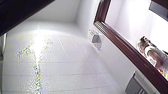 Slender blonde is pissing in the public toilet