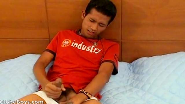 Tanned gay with tattoos is wanking his hard dick